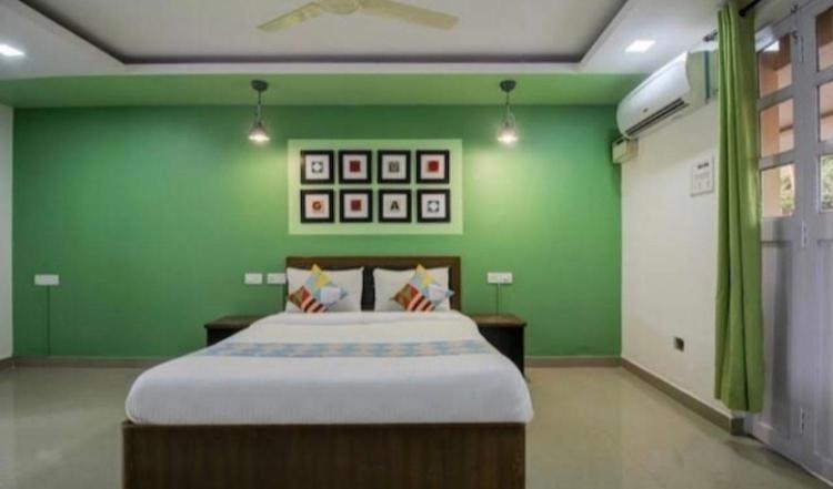 马普萨Hotel Sai Advika的一间卧室设有一张带绿色墙壁的大床