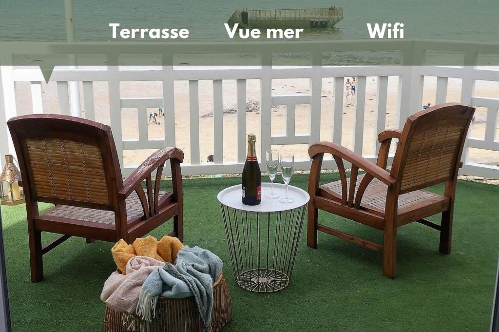 阿罗芒什莱班Appartement de standing - avec terrasse et vue mer的两把椅子和一张桌子及一瓶葡萄酒