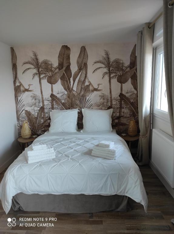 库尔瑟勒·苏尔·梅尔Appartement de charme的一间卧室配有一张棕榈树壁画床
