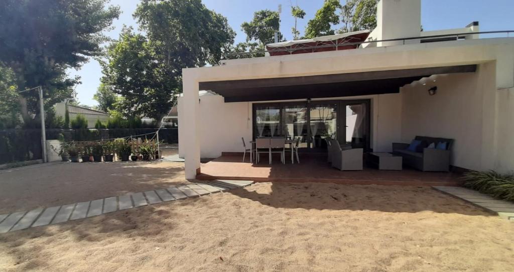 蓬塔翁布里亚Casa Punta de Los Ingleses的白色的小房子,设有庭院和桌子