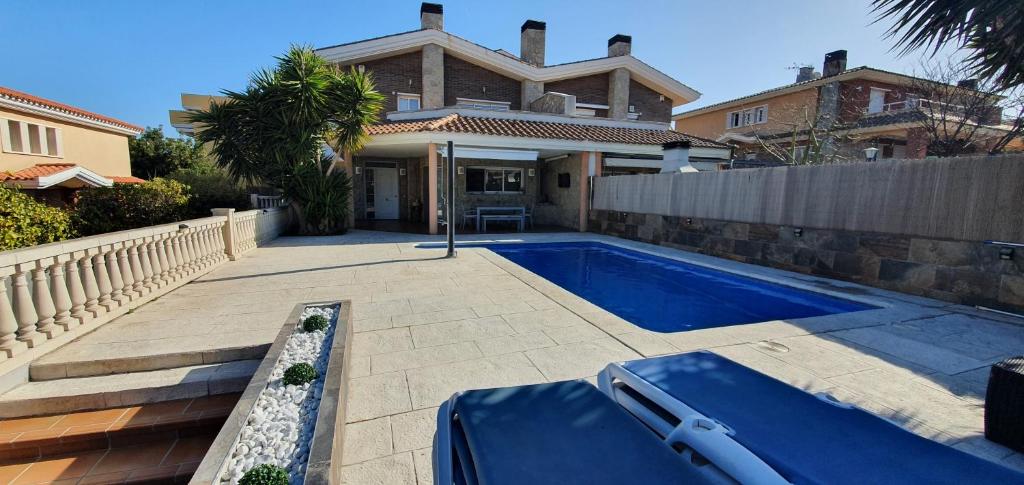 萨洛Villa castelló salou的房屋前的游泳池