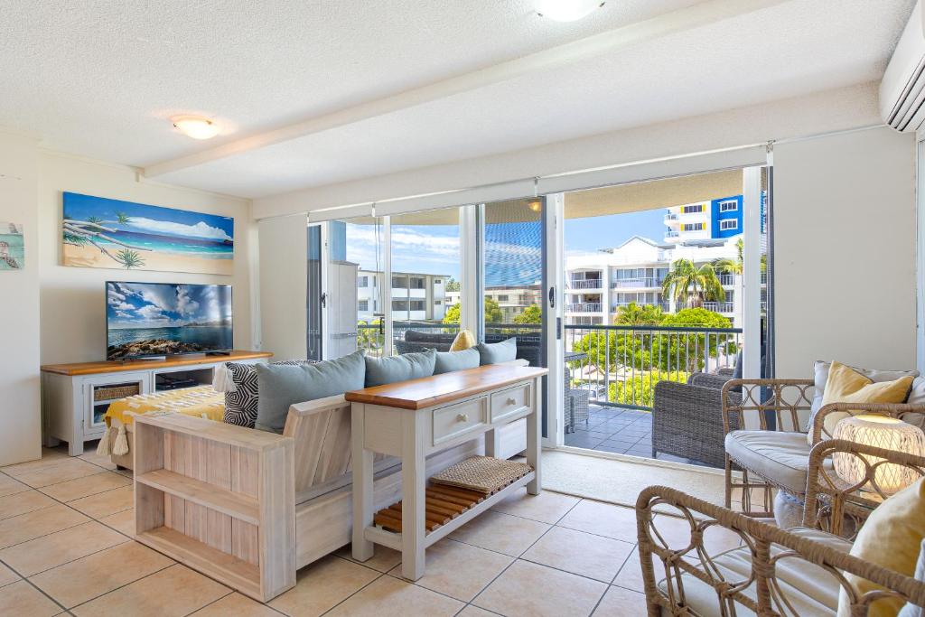 玛志洛珊瑚海公寓 的客厅配有沙发和桌子