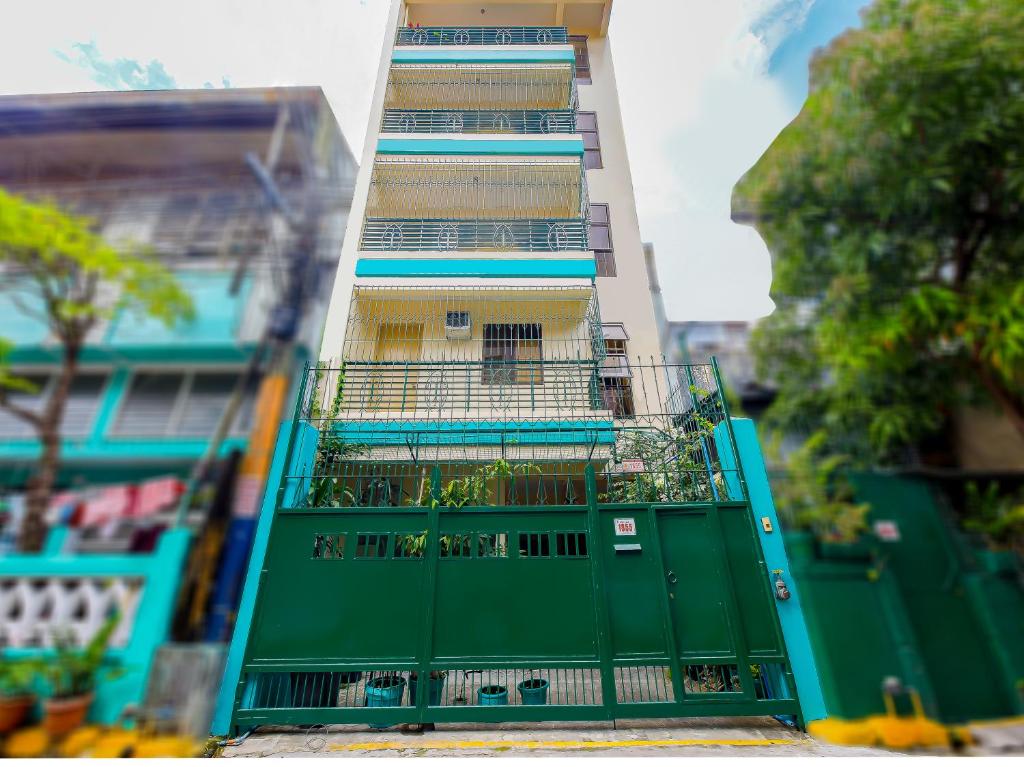 马尼拉OYO 840 Orangenest Apartelle的绿色高楼,带绿门