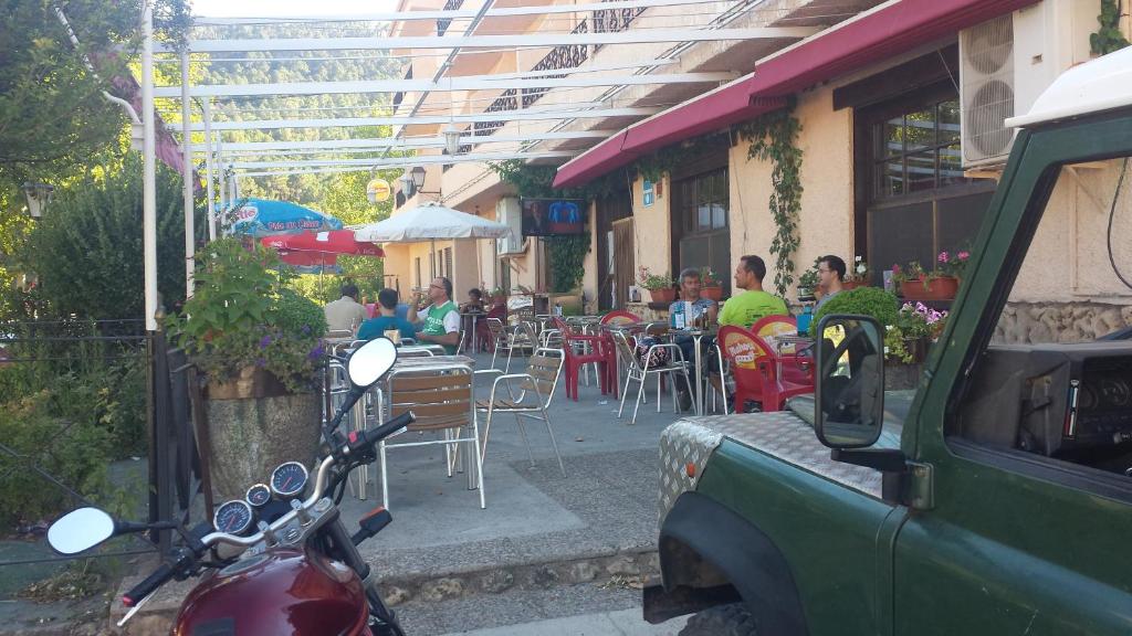里奥帕尔布龙赛斯餐厅旅馆的停在餐厅前面的摩托车,人们坐在桌子上