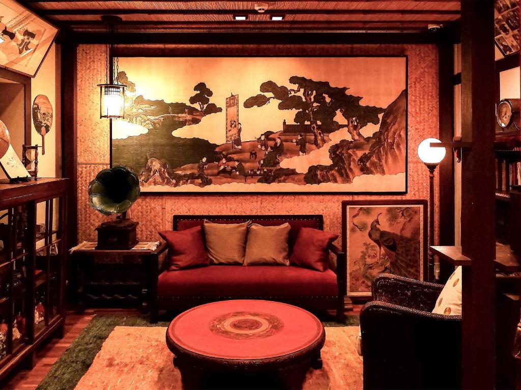 京都祇园紘酒店的客厅配有红色沙发和大画作