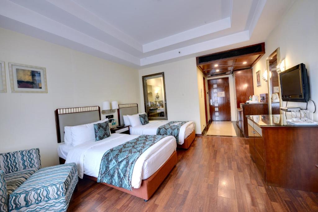 班加罗尔Fortune Select JP Cosmos, Bengaluru - Member ITC's hotel group的酒店客房设有两张床和一台平面电视。