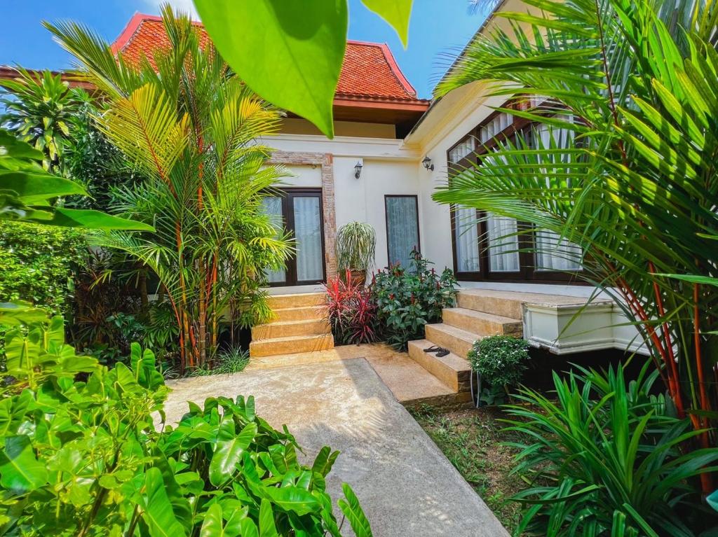 通奈潘海滩Villas Chaba的前面有树木和植物的房子