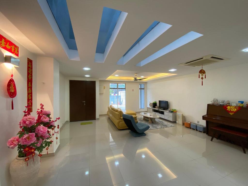 史里肯邦安Entire Residential Home•Jia Residences Bkt Serdang沙登温暖的家的客厅设有蓝色的天花板和沙发。