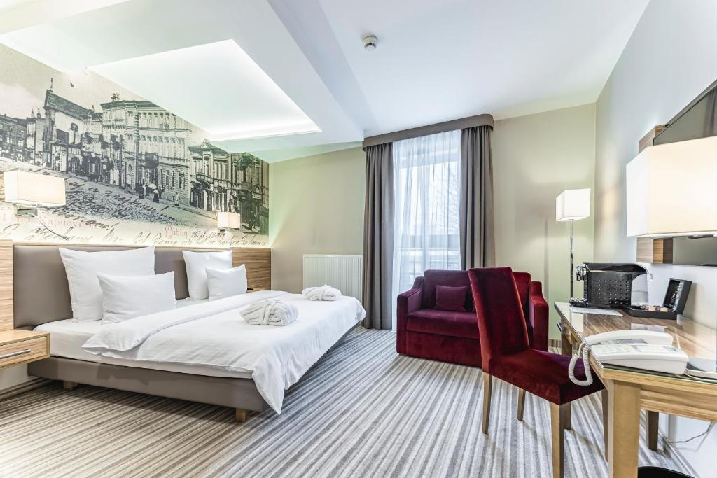卢布林维尼亚夫斯基酒店的配有一张床和一张书桌的酒店客房