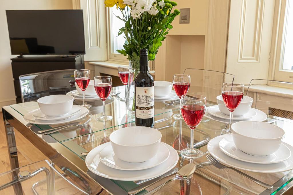 伦敦Paddington Gardens的玻璃桌,装有一瓶葡萄酒和花瓶
