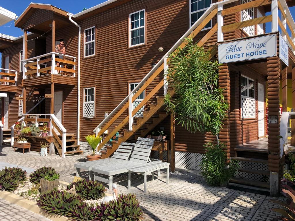 库尔克岛Blue Wave Guest House的前面设有长凳的木屋