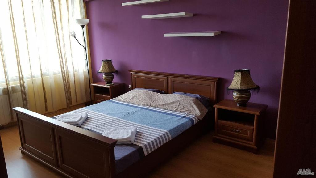 瓦尔纳Апартамент Орхид Хилс的一间卧室配有一张紫色墙壁的床