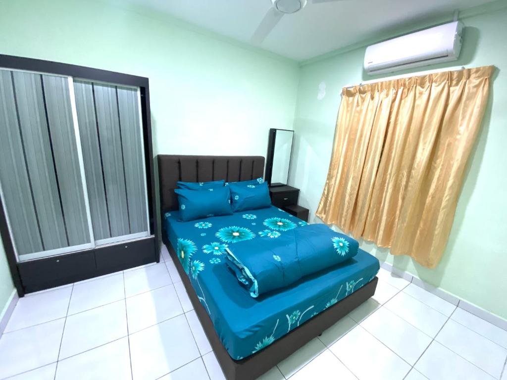 马日丹那Green House Homestay的一间卧室配有一张带蓝色床单的床和一扇窗户。