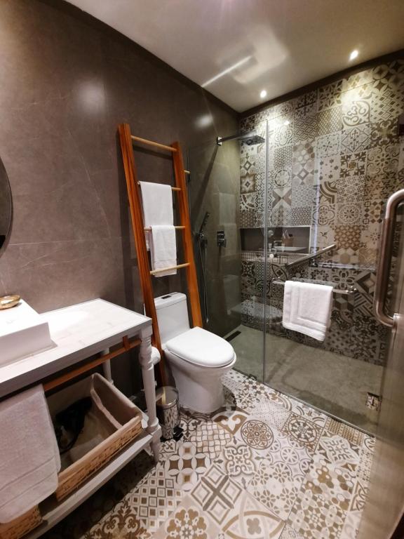 昆卡Hostal Suite Le Fabrique的带淋浴、卫生间和盥洗盆的浴室