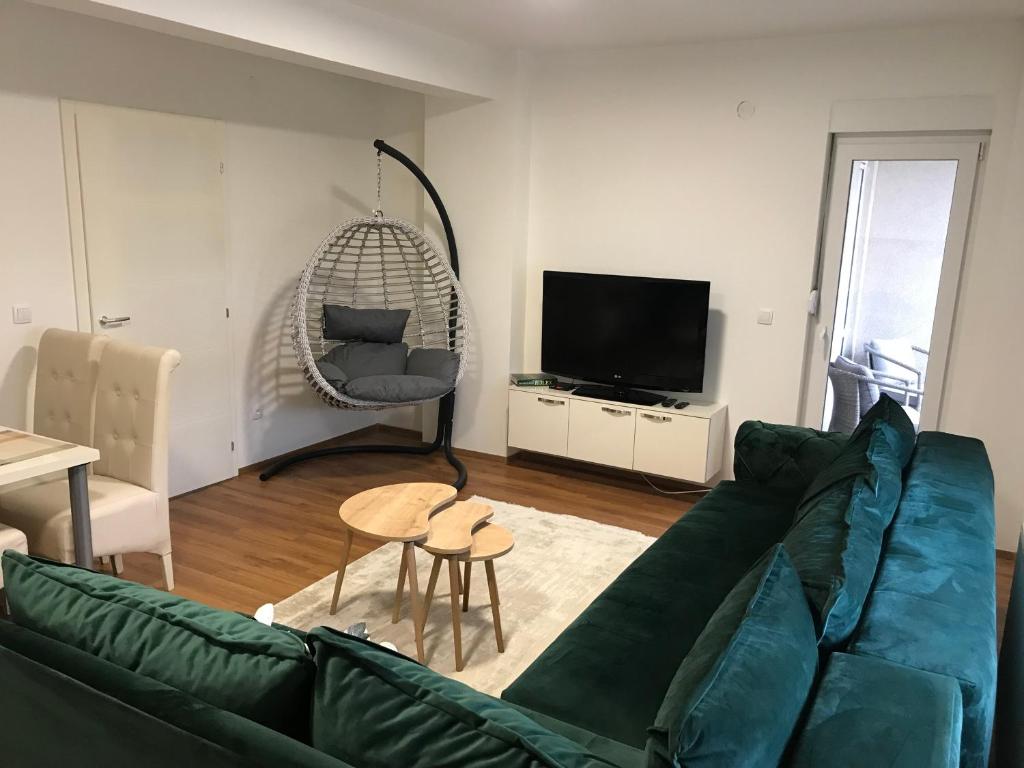 新帕扎尔Green Apartment的客厅配有绿色沙发和电视
