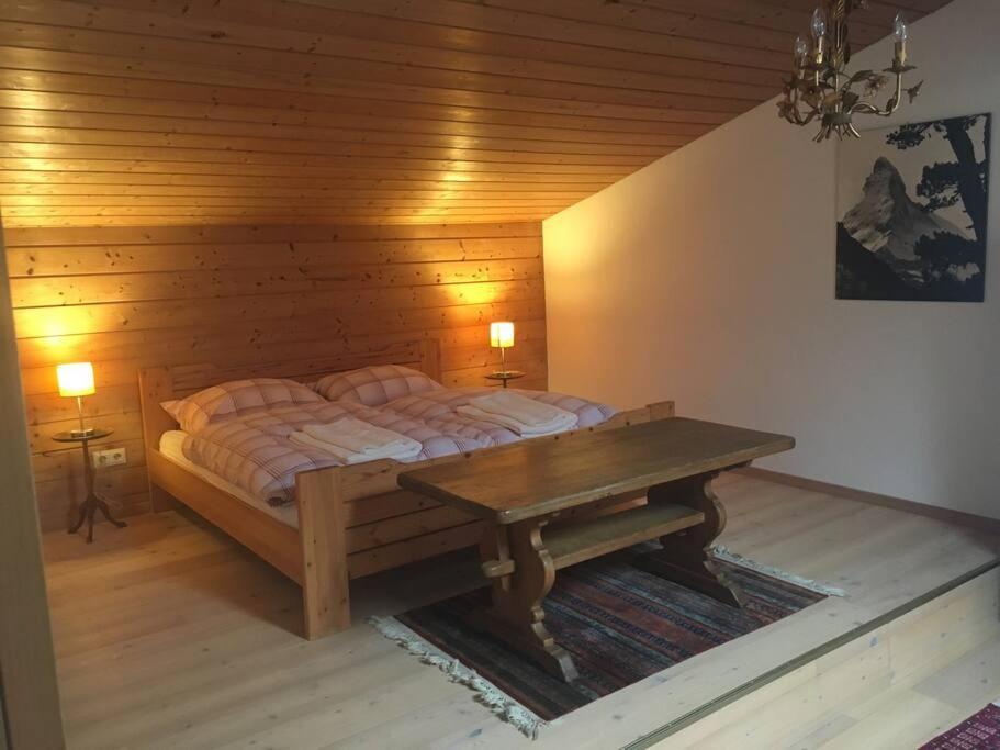 基茨比厄尔Gundhabing flat的一间卧室配有一张床和一张木桌