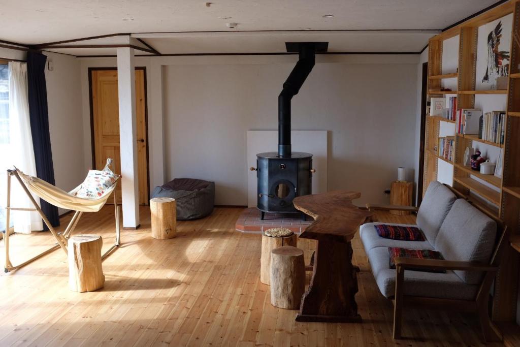 安昙野市Azumino Fukuro Guesthouse - Vacation STAY 21913v的带沙发和燃木炉的客厅