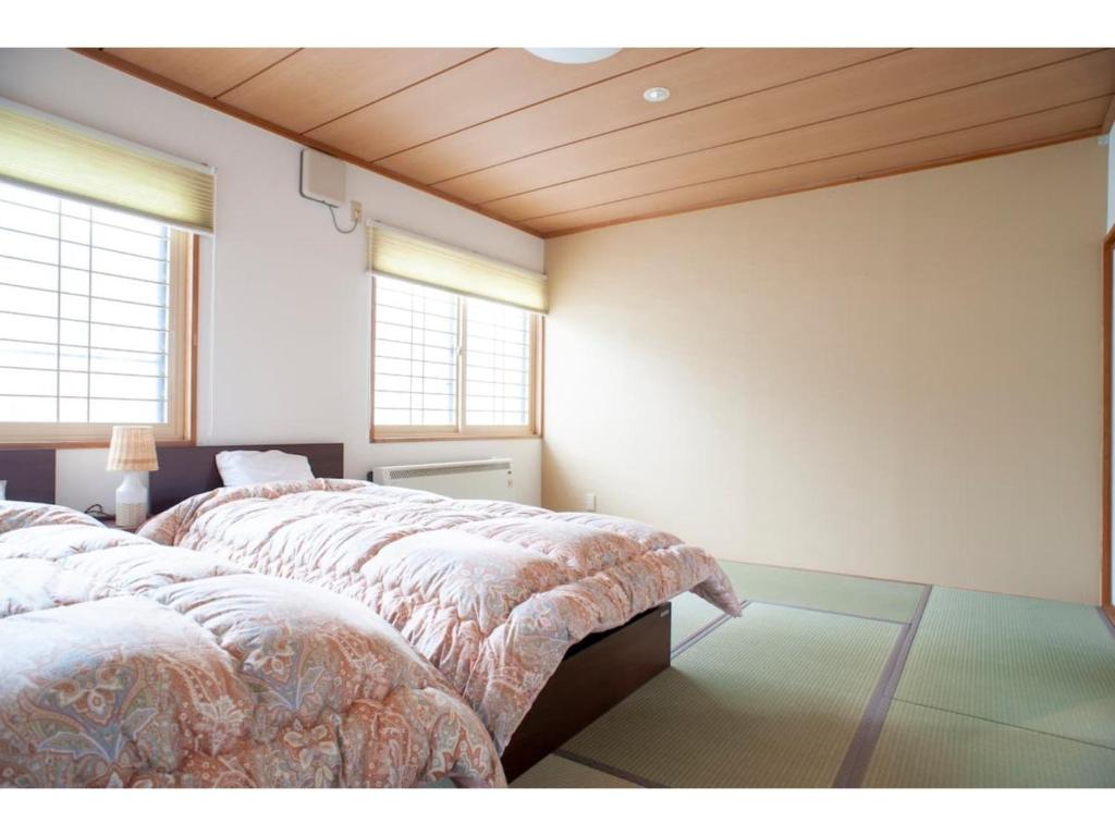 钏路Guest House Tou - Vacation STAY 26352v的带2扇窗户的客房内的2张床