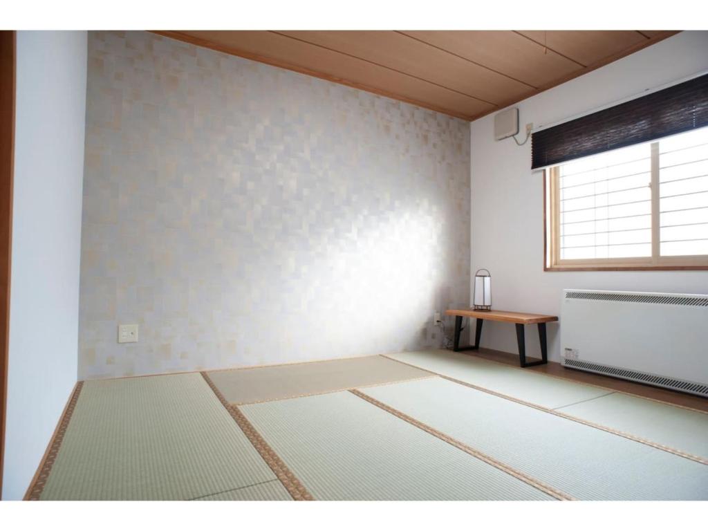 钏路Guest House Tou - Vacation STAY 26356v的客厅配有桌子和窗户