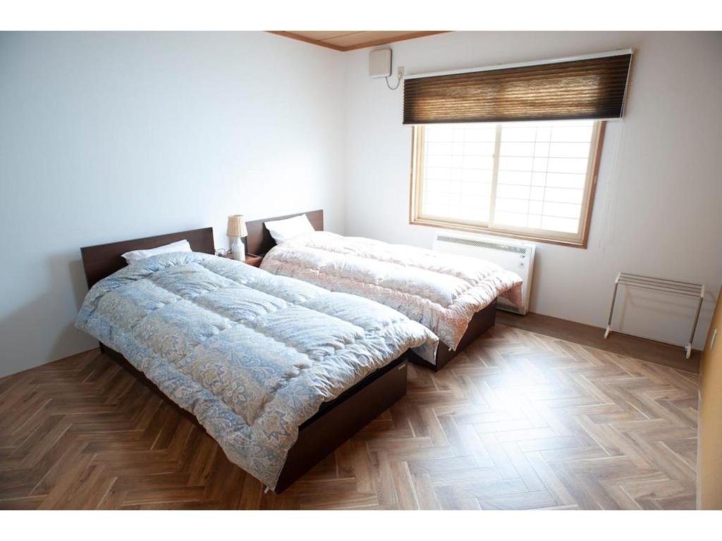 钏路Guest House Tou - Vacation STAY 26359v的一间卧室设有两张床和窗户。