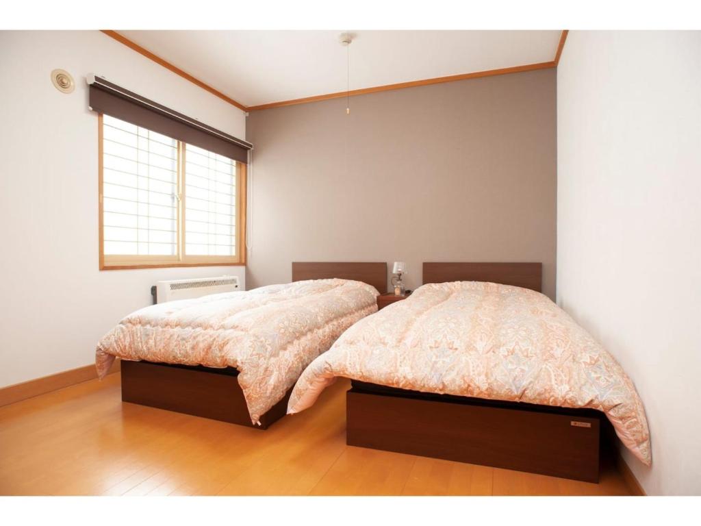 钏路Guest House Tou - Vacation STAY 26333v的一间卧室设有两张床和窗户。