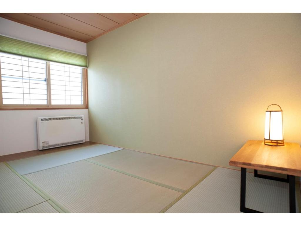 钏路Guest House Tou - Vacation STAY 26341v的一个空房间,有桌子和窗口