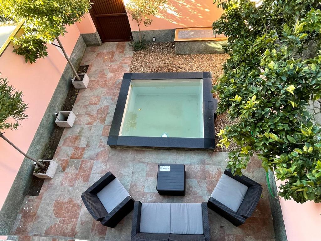 梅里达CERES Home的享有带椅子和植物的游泳池的顶部景致