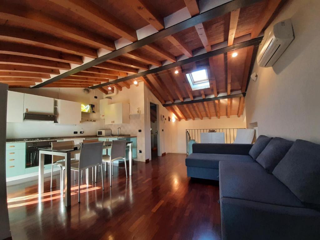 帕尔马Appartamento sui tetti di Parma的一间带蓝色沙发的客厅和一间厨房