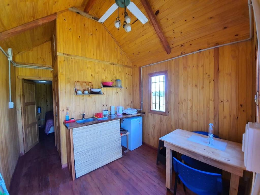 瓜莱瓜伊Chacra Mandala的小木屋内的厨房配有木桌