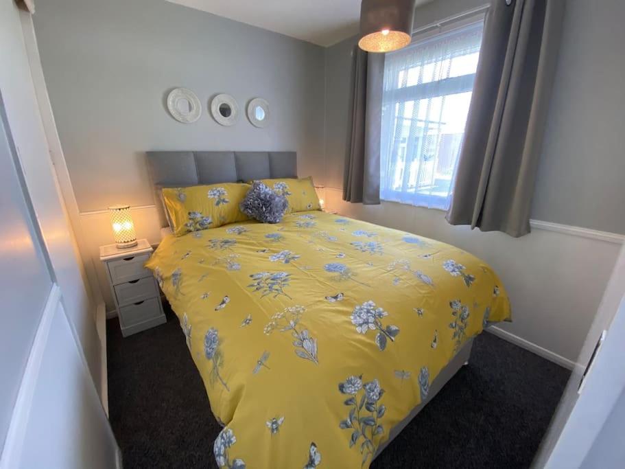 ScratbyEast Coast Chalets 57 at California Sands的一间卧室设有黄色的床和窗户。