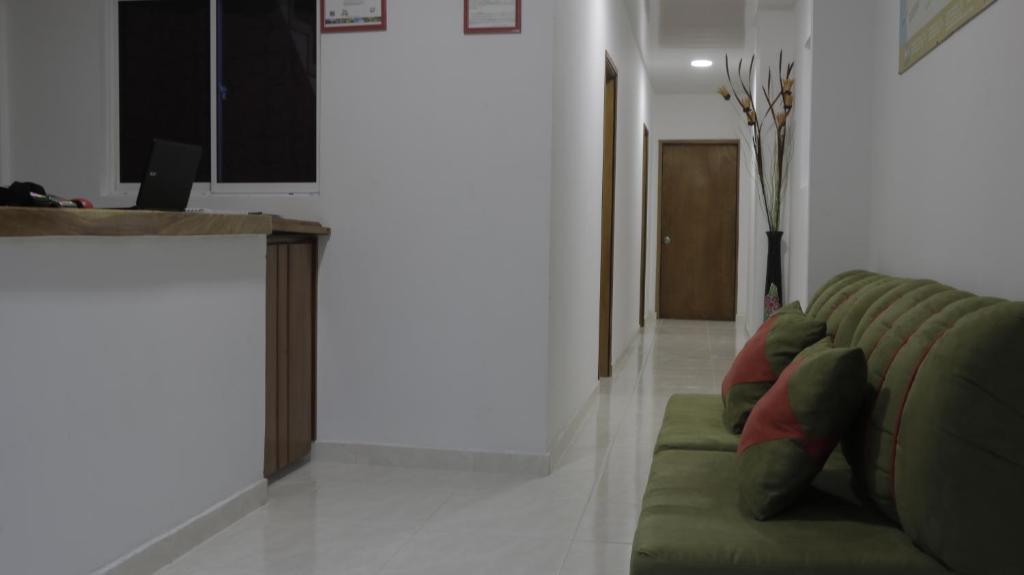 GuachacaPuerto Caribe Hostal的客厅配有绿色沙发和台面