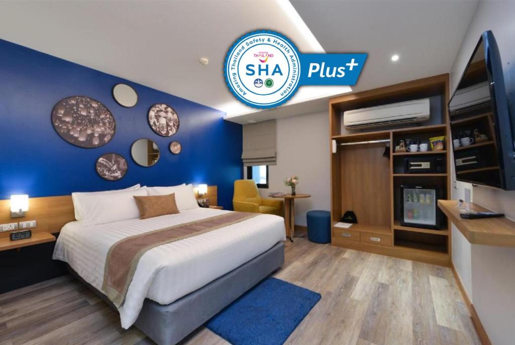 曼谷Aspira One Sutthisan的酒店客房,设有床铺和蓝色的墙壁