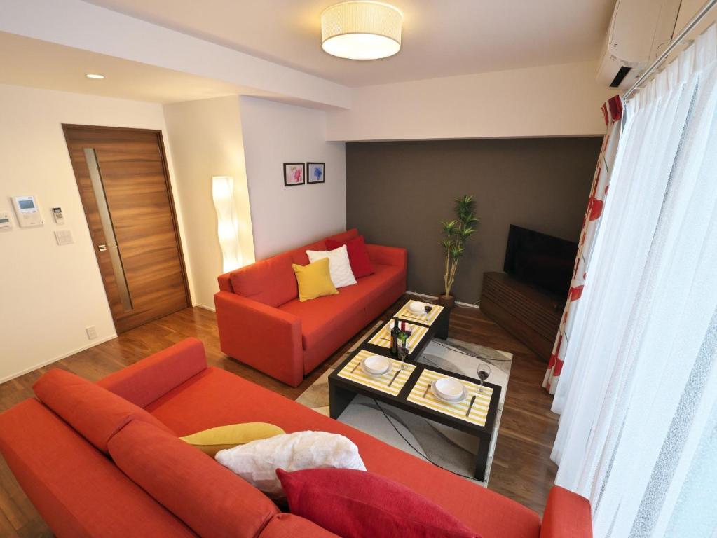 名古屋23rd Prosper Marunouchi - Vacation STAY 28741v的客厅配有红色的沙发和桌子