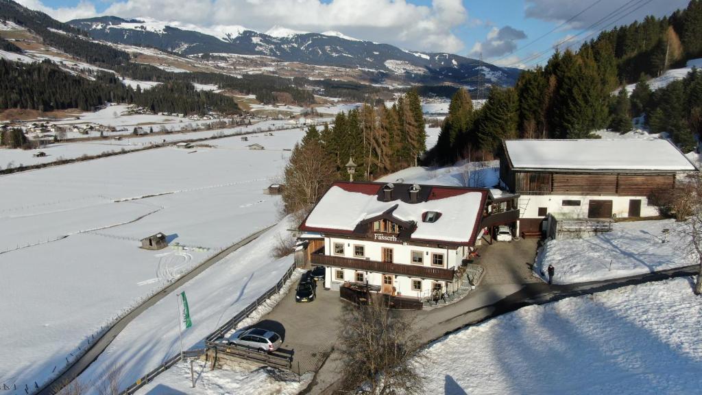 维尔德科格尔山麓布兰贝格帕瑟霍夫旅馆的雪中房屋的空中景观