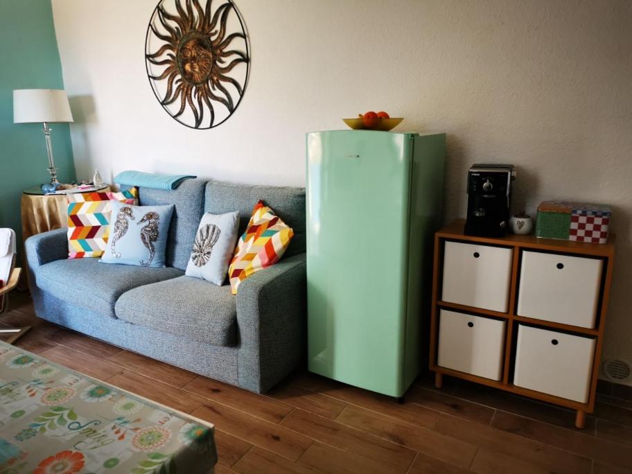 杰若米斯Cara Catherine的客厅配有蓝色沙发和绿色冰箱