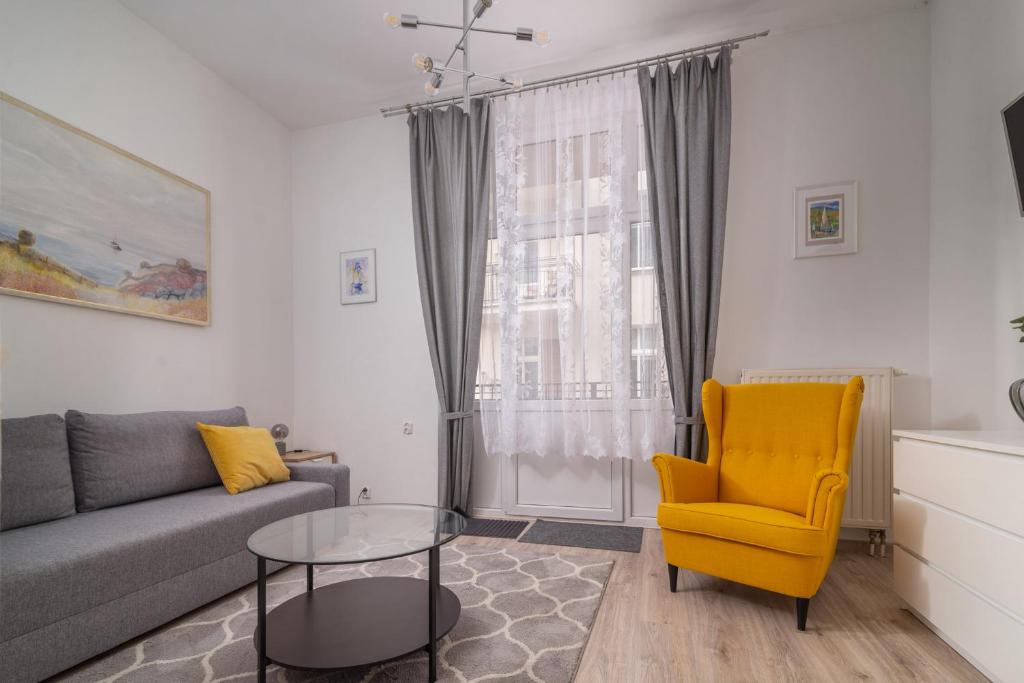 索波特Apartament Mesa - NoclegiSopot的带沙发和黄色椅子的客厅