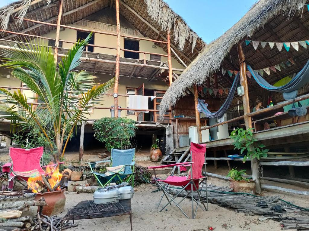 托弗海滩Casa Surf Lodge - Tofo的一群椅子和一火炉在建筑物前