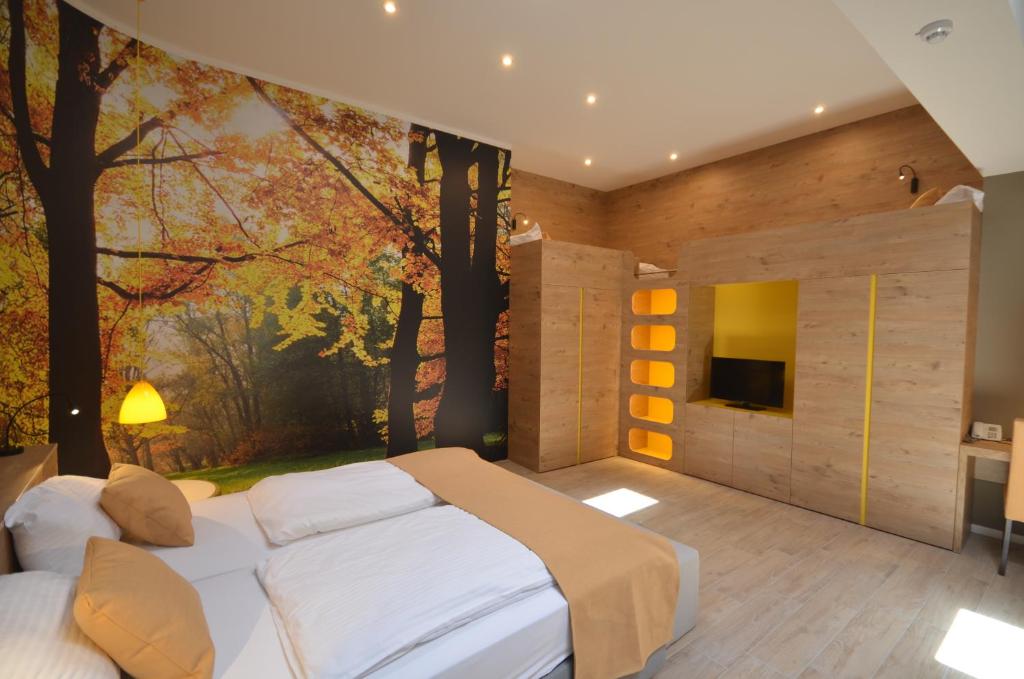 卢布尔雅那伊莫尼克酒店的卧室配有一张大床,墙上挂有绘画作品