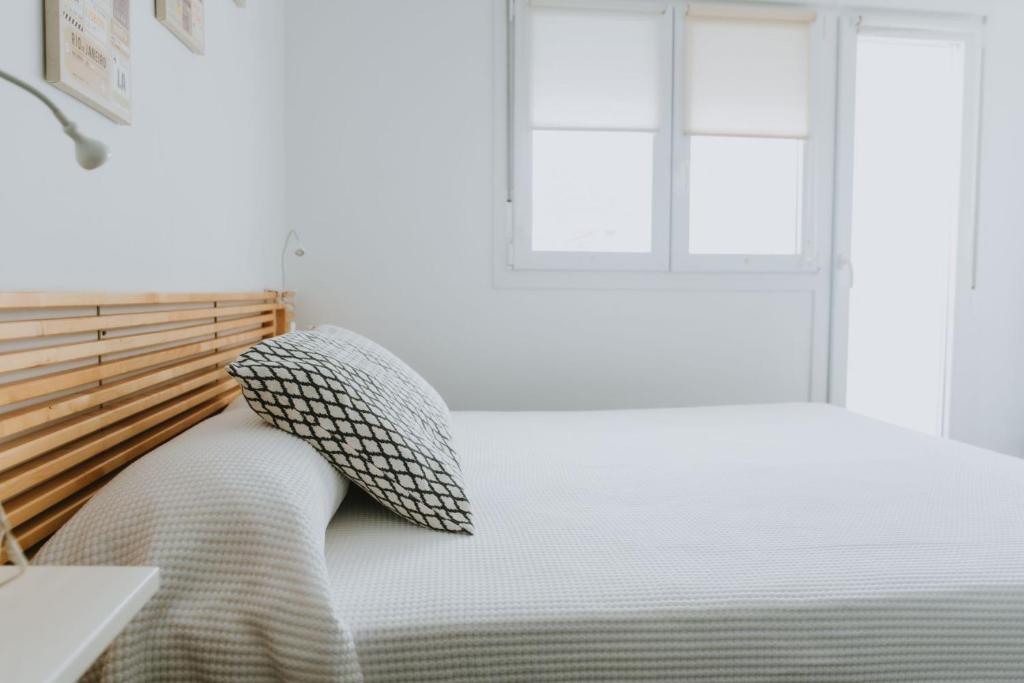 萨阿拉德洛斯阿图内斯Apartamentos ZHR 2的一间卧室配有一张带枕头和窗户的床