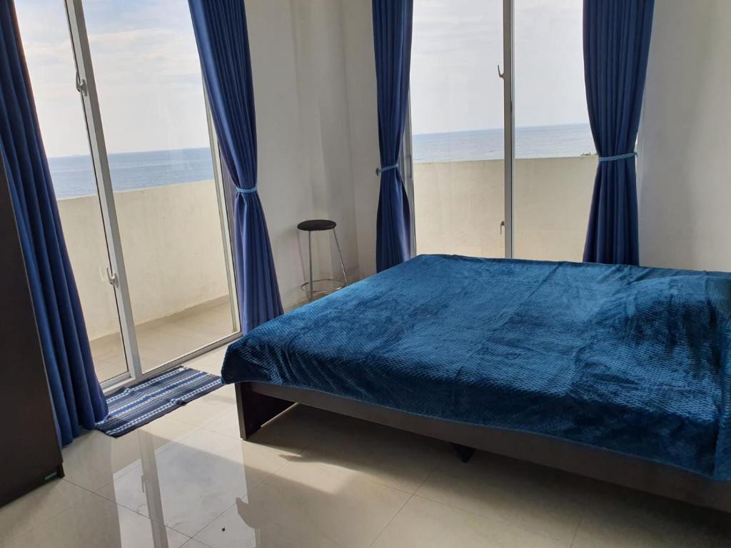 代希瓦勒New 2 bedroom apartment, 100m away from the beach的一间卧室设有蓝色的床和大窗户