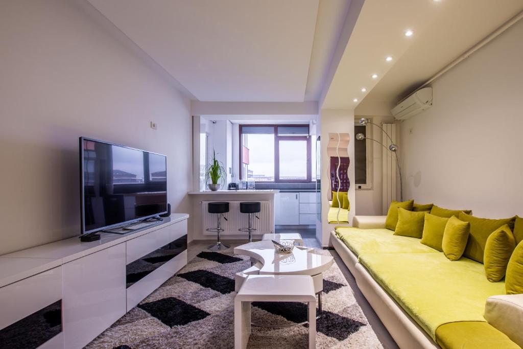 Roşu3 Room Luxury Residence Militari M2+3的客厅设有黄色沙发和电视