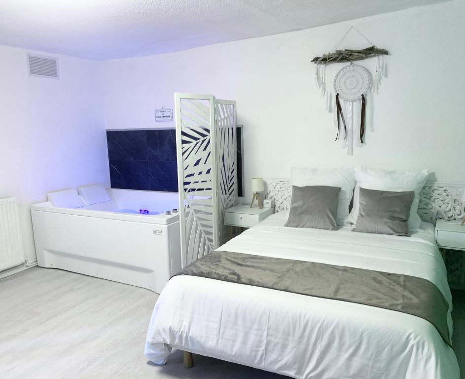 圣艾蒂安Le Golf Balnéo - Cosy & SPA的白色卧室配有床和书桌