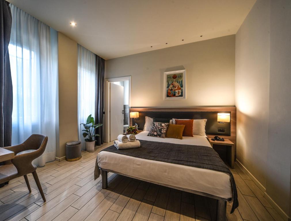 米兰扎拉米兰酒店的一间卧室配有一张大床和一把椅子