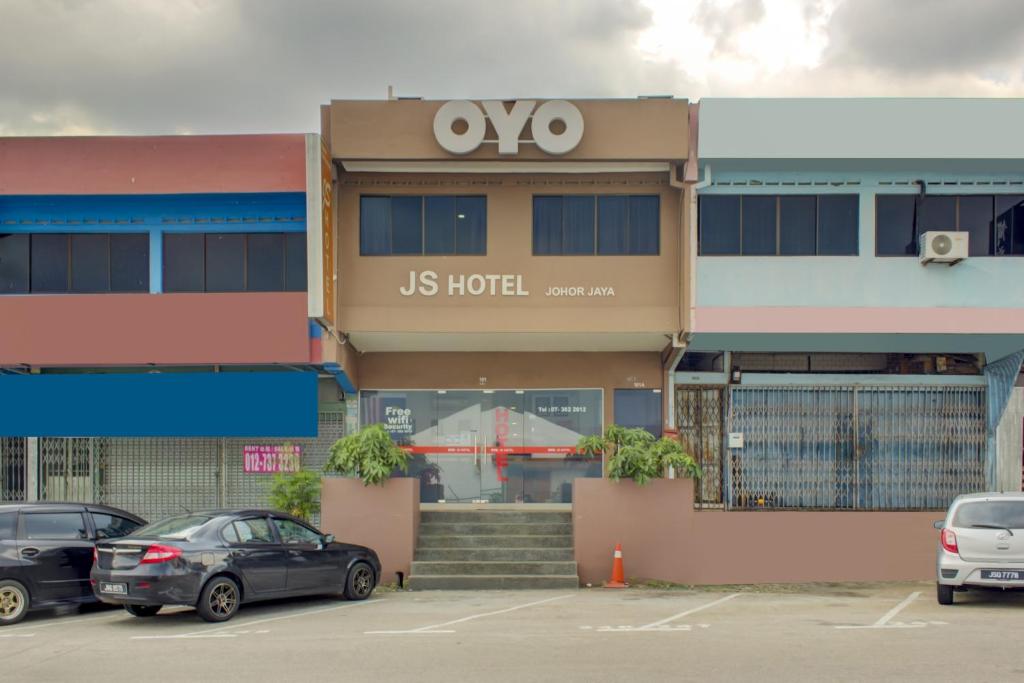 新山Super OYO 89985 Js Hotel的一家酒店,停车场内有车辆停放
