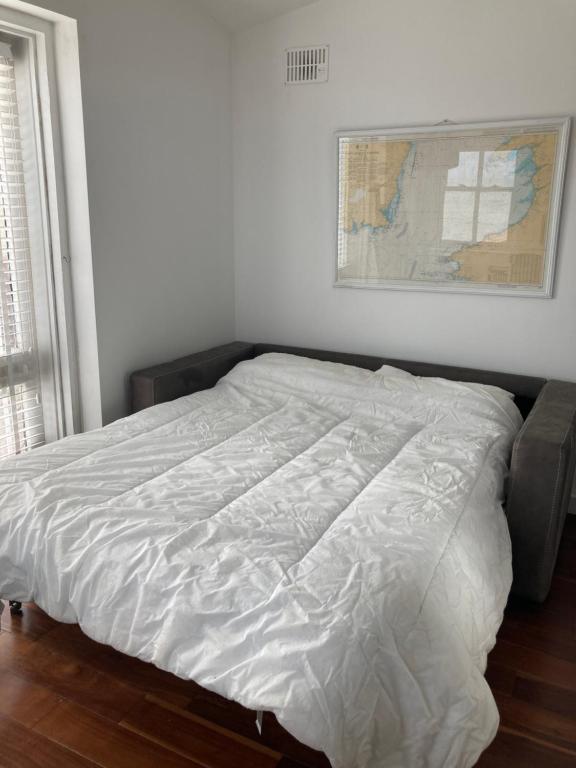 邓莫尔东Sandy Cove的卧室内的一张床铺,墙上有地图