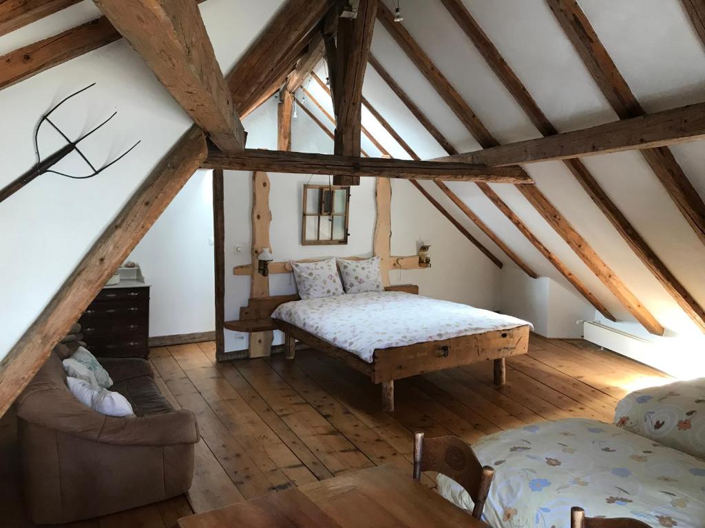 La SagneHôtel Von Bergen的阁楼上一间卧室配有一张床和一张沙发