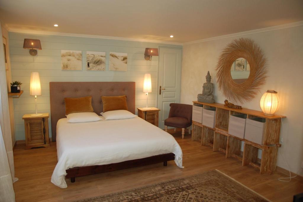 布吕热Villa Chaleemar的一间卧室配有一张大床和镜子
