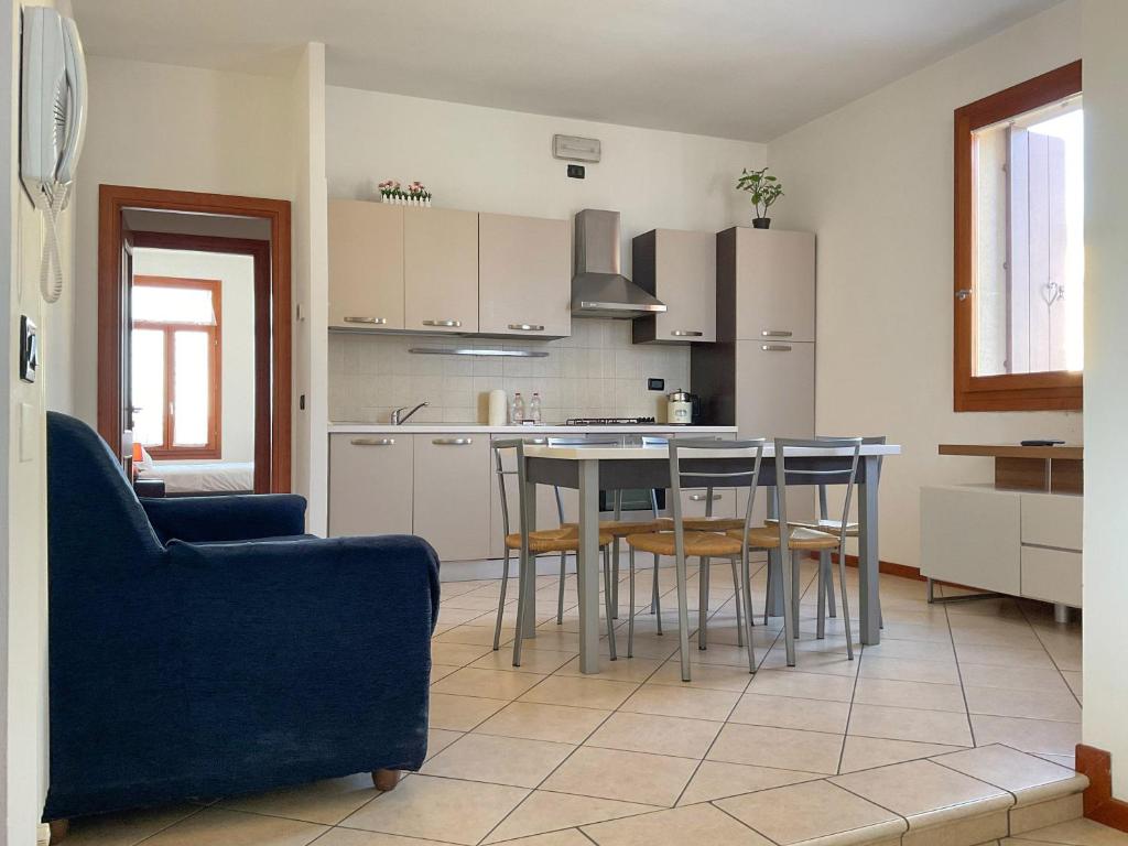 孔塞尔韦Blue Apartment Conselve的厨房配有桌椅和蓝色沙发。