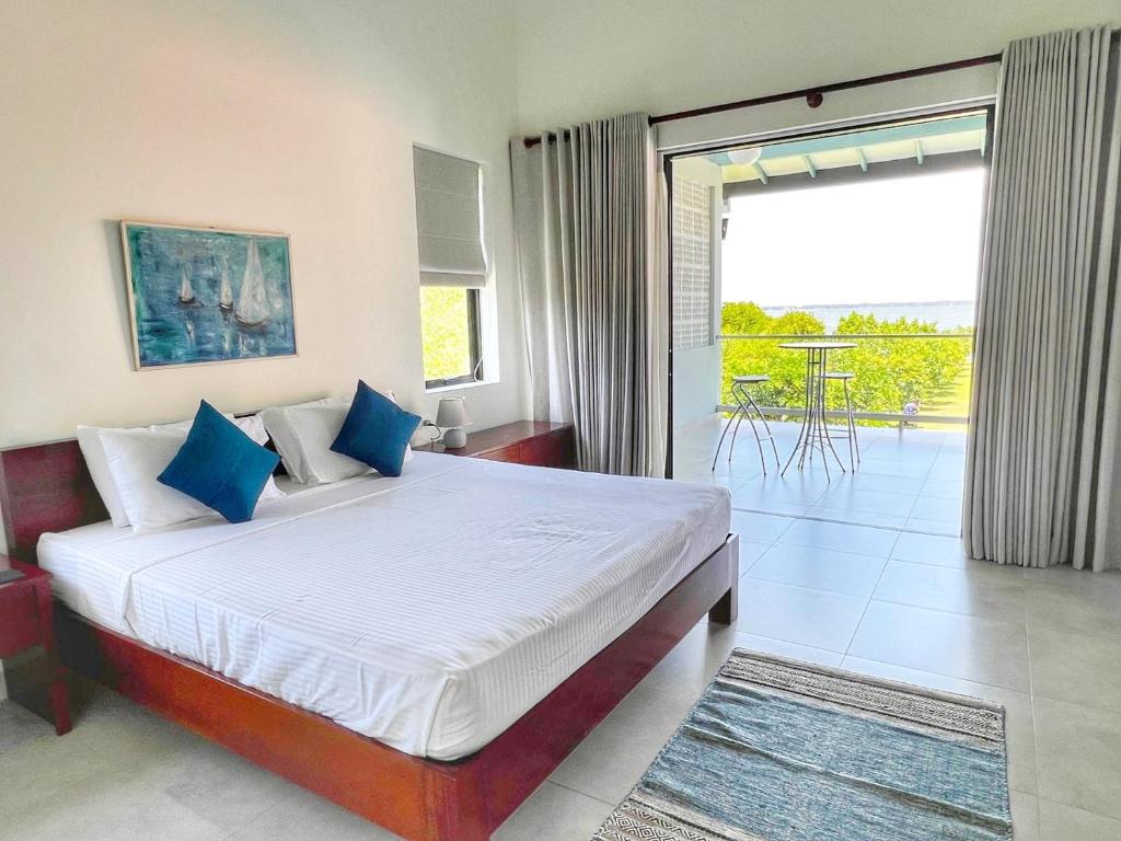 尼甘布Villa Lagoonscape的一间带大床的卧室和一个阳台
