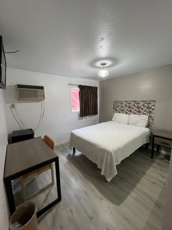 圣安东尼奥Best Inn Motel Seaworld & Lackland AFB的卧室配有白色的床和桌子